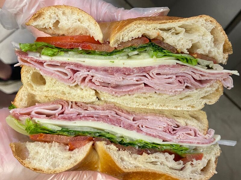 Debbie's Italian sandwich cut in half: ham, salami, provolone, lettuce and tomato on a roll